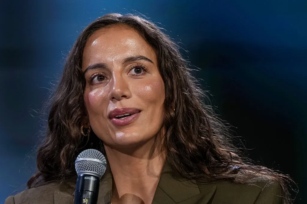 Portrait of Mira Murati speaking into a microphone.