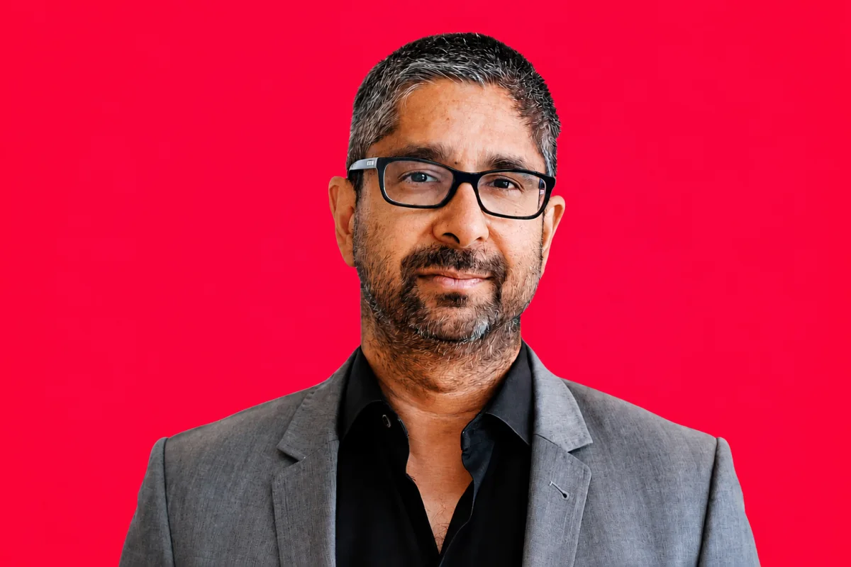 Portrait of Vijay Pande against a red background.