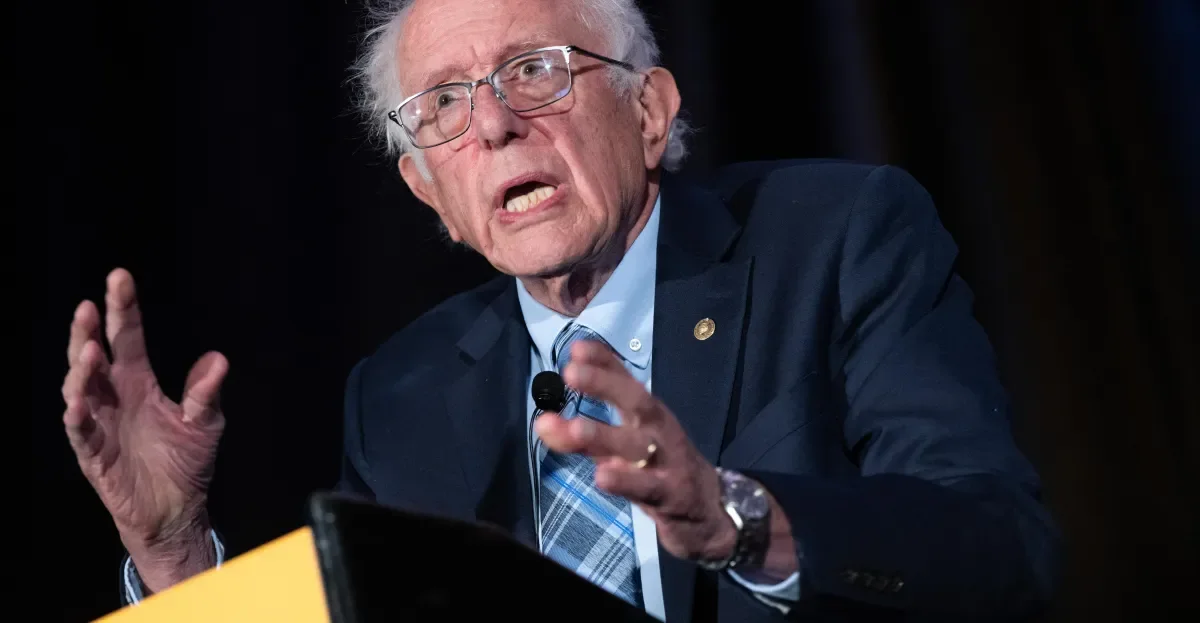 Senator Bernie Sanders gesturing while speaking at a podium.