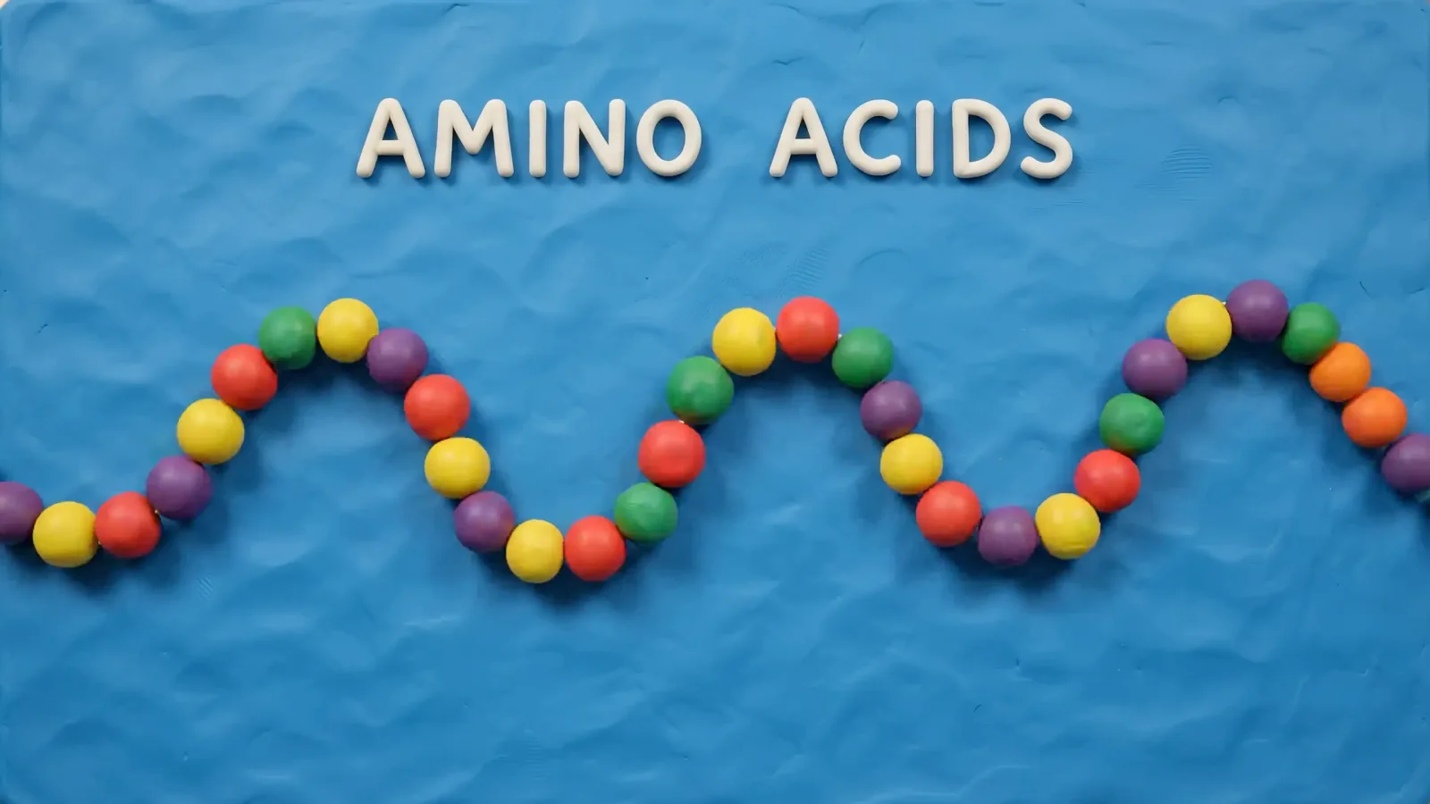 A stop-motion style visualization of amino acids and a molecular chain on a blue background.